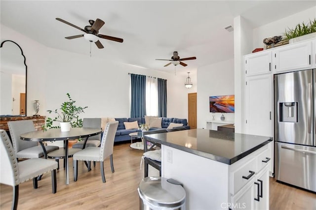 8103 David Way, Jurupa Valley, CA 92509 - kitchen featuring stainless steel fridge, a ceiling fan, light wood-style flooring, dark countertops, and white cabinetry