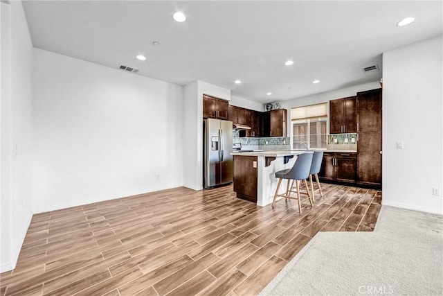 70 Linden Ln, Temple City, CA 91780 - kitchen featuring stainless steel refrigerator with ice dispenser, a kitchen bar, dark brown cabinets, light countertops, and tasteful backsplash