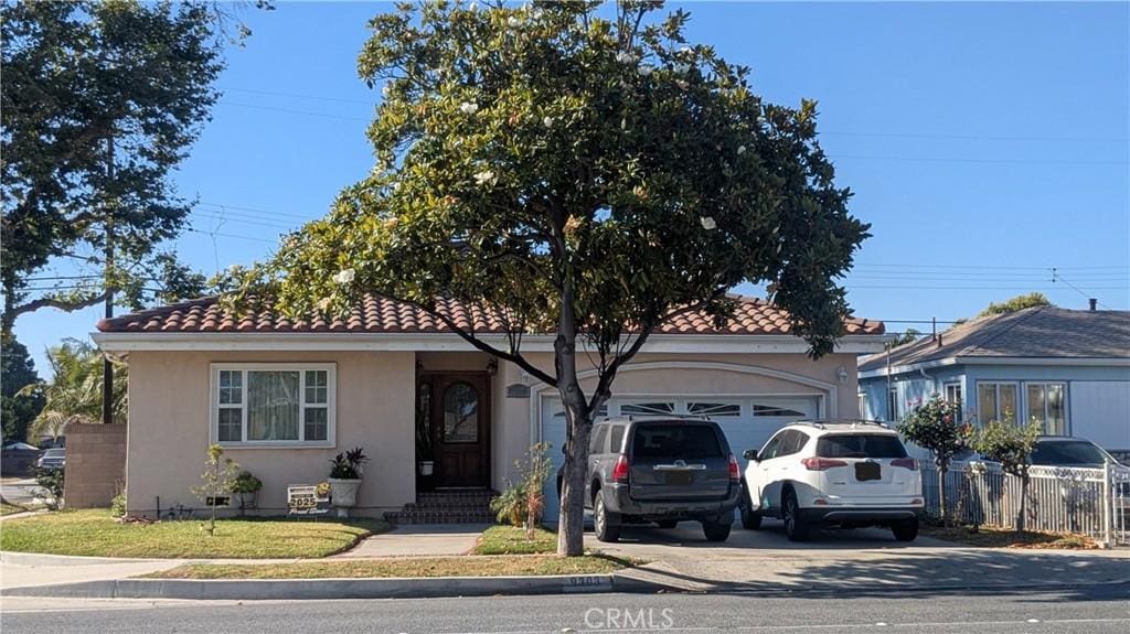 9303 Foster Rd, Downey, CA 90242 - view of front of house featuring stucco siding, driveway, a garage, and a tile roof