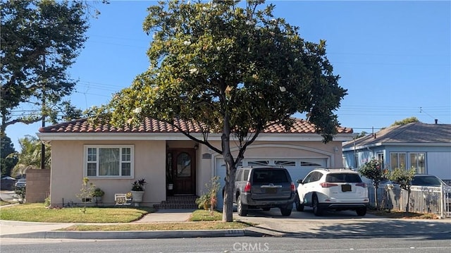 9303 Foster Rd, Downey, CA 90242 - view of front of house featuring stucco siding, driveway, a garage, and a tile roof