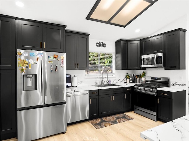 1324 Windermere Ct, Palmdale, CA 93551 - kitchen featuring stainless steel appliances, dark cabinetry, light stone countertops, light wood finished floors, and recessed lighting
