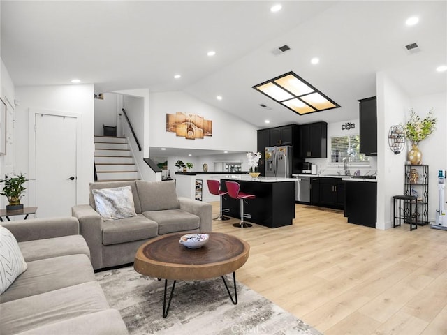 1324 Windermere Ct, Palmdale, CA 93551 - living area with stairs, light wood-type flooring, vaulted ceiling, and recessed lighting