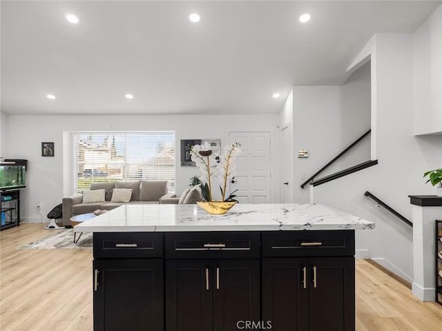 1324 Windermere Ct, Palmdale, CA 93551 - kitchen with dark cabinetry, light wood finished floors, light stone countertops, open floor plan, and recessed lighting
