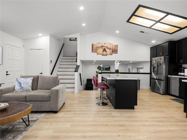 1324 Windermere Ct, Palmdale, CA 93551 - kitchen with appliances with stainless steel finishes, dark cabinetry, lofted ceiling, a center island, and open floor plan