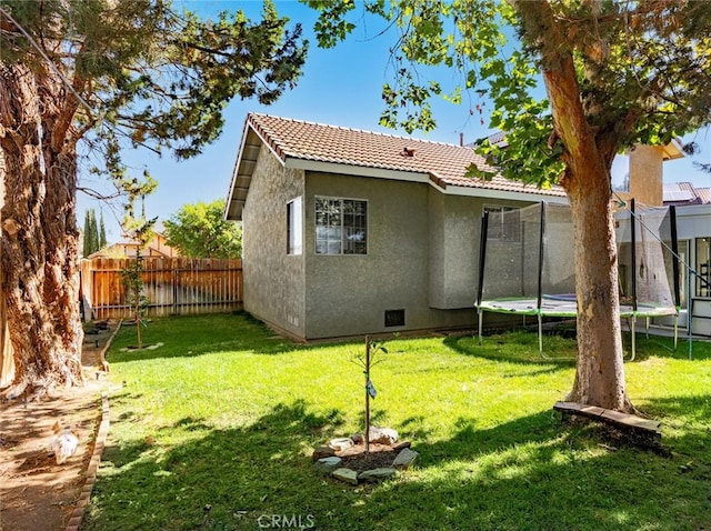 1324 Windermere Ct, Palmdale, CA 93551 - back of house with stucco siding, a trampoline, and a tile roof
