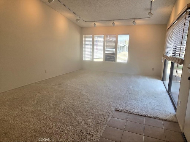 8566 Larkhall Cir Unit 808A, Huntington Beach, CA 92646 - carpeted spare room with rail lighting, tile patterned floors, and a textured ceiling