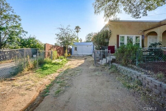 6093 Troth St, Jurupa Valley, CA 91752 - view of side of home featuring stucco siding and a gate