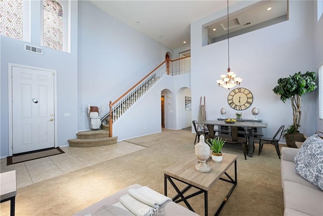750 Multnomah Ct, San Jacinto, CA 92582 - carpeted living area featuring a towering ceiling, arched walkways, a chandelier, stairway, and recessed lighting