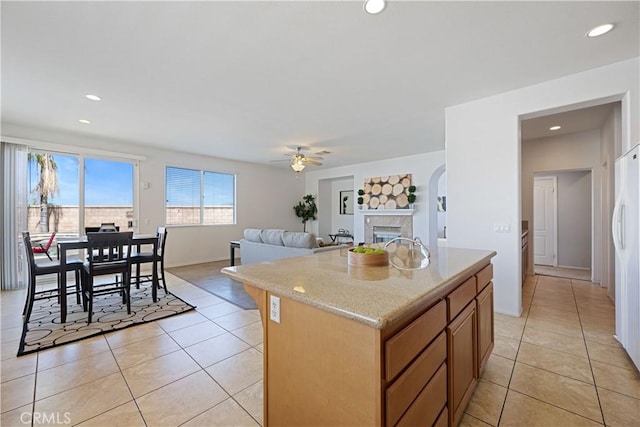 750 Multnomah Ct, San Jacinto, CA 92582 - kitchen with light tile patterned flooring, a ceiling fan, a center island, a fireplace, and open floor plan