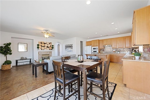 750 Multnomah Ct, San Jacinto, CA 92582 - dining room featuring light tile patterned floors, arched walkways, a ceiling fan, a glass covered fireplace, and recessed lighting