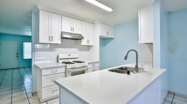 1531 E Ln Palma Ave Unit C2, Anaheim, CA 92805 - kitchen with under cabinet range hood, white gas range, light tile patterned floors, and white cabinetry