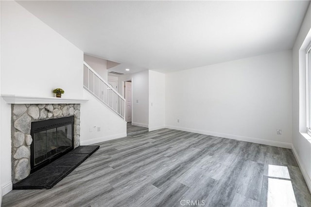 14791 Mountain High Dr, Fontana, CA 92337 - unfurnished living room featuring wood finished floors, a fireplace, stairs, and recessed lighting