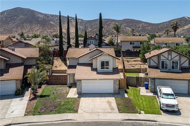 14791 Mountain High Dr, Fontana, CA 92337 - traditional-style home with stone siding, a residential view, a tile roof, a mountain view, and driveway