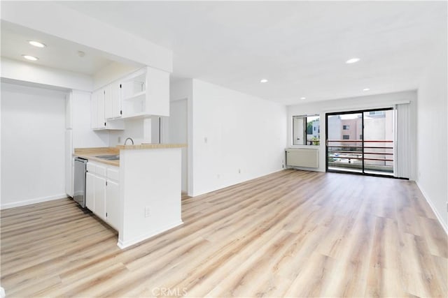 1119 Albany St Unit 226, Los Angeles, CA 90015 - kitchen featuring open shelves, light wood-style flooring, light countertops, white cabinetry, and dishwasher