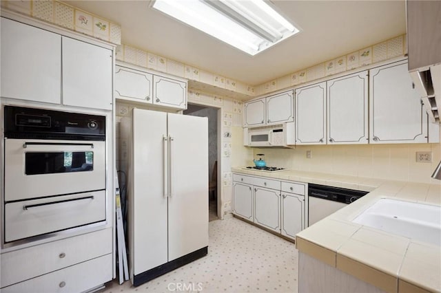 19309 Flowers Ct, Newhall, CA 91321 - kitchen with white appliances, tile countertops, a warming drawer, light flooring, and tasteful backsplash