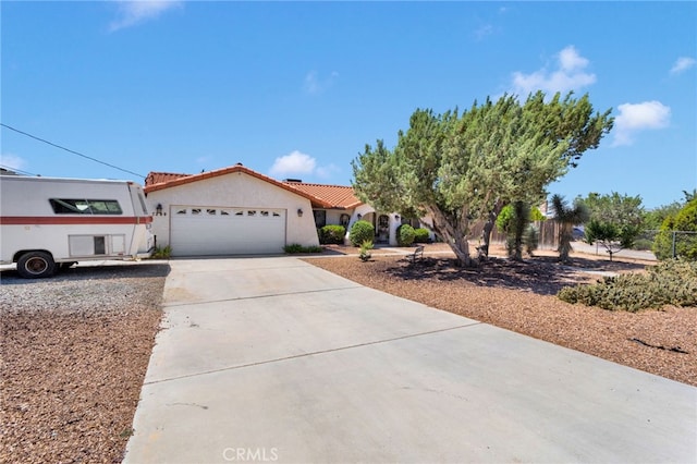 7390 Chase Ave, Hesperia, CA 92345 - mediterranean / spanish-style home featuring a garage, driveway, stucco siding, and a tiled roof