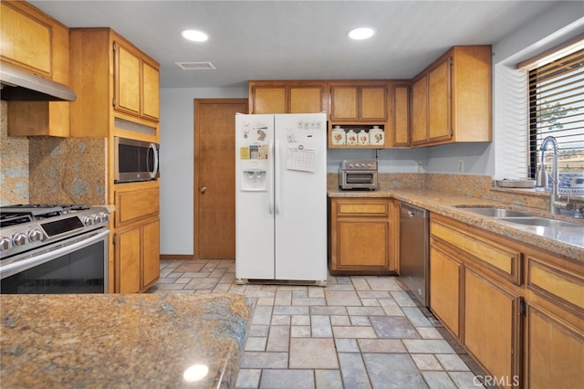 7390 Chase Ave, Hesperia, CA 92345 - kitchen with stainless steel appliances, stone tile flooring, brown cabinets, decorative backsplash, and recessed lighting