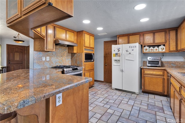 7390 Chase Ave, Hesperia, CA 92345 - kitchen featuring appliances with stainless steel finishes, under cabinet range hood, brown cabinets, tasteful backsplash, and recessed lighting
