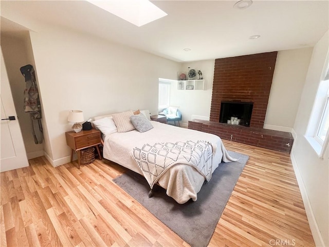 4574 Whaley Ave, Long Beach, CA 90807 - bedroom with a skylight, light wood finished floors, and a fireplace