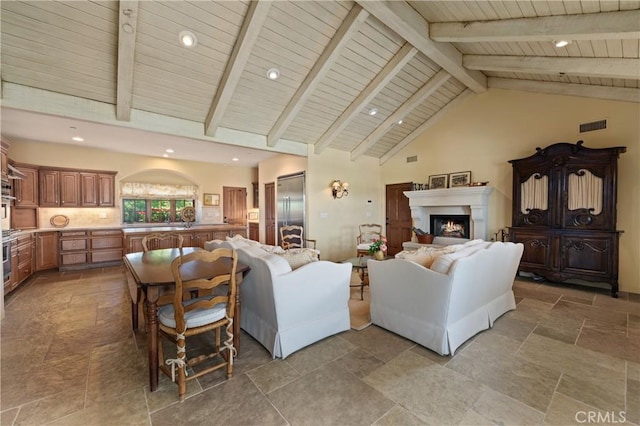 1559 Rolling Hills Rd, Santa Ynez, CA 93460 - living room featuring stone tile flooring, a wooden ceiling with exposed beams, high vaulted ceiling, and a warm lit fireplace