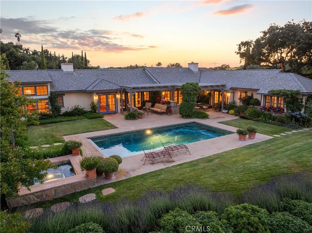 1559 Rolling Hills Rd, Santa Ynez, CA 93460 - back of house at dusk with french doors, a chimney, a lawn, and a patio area