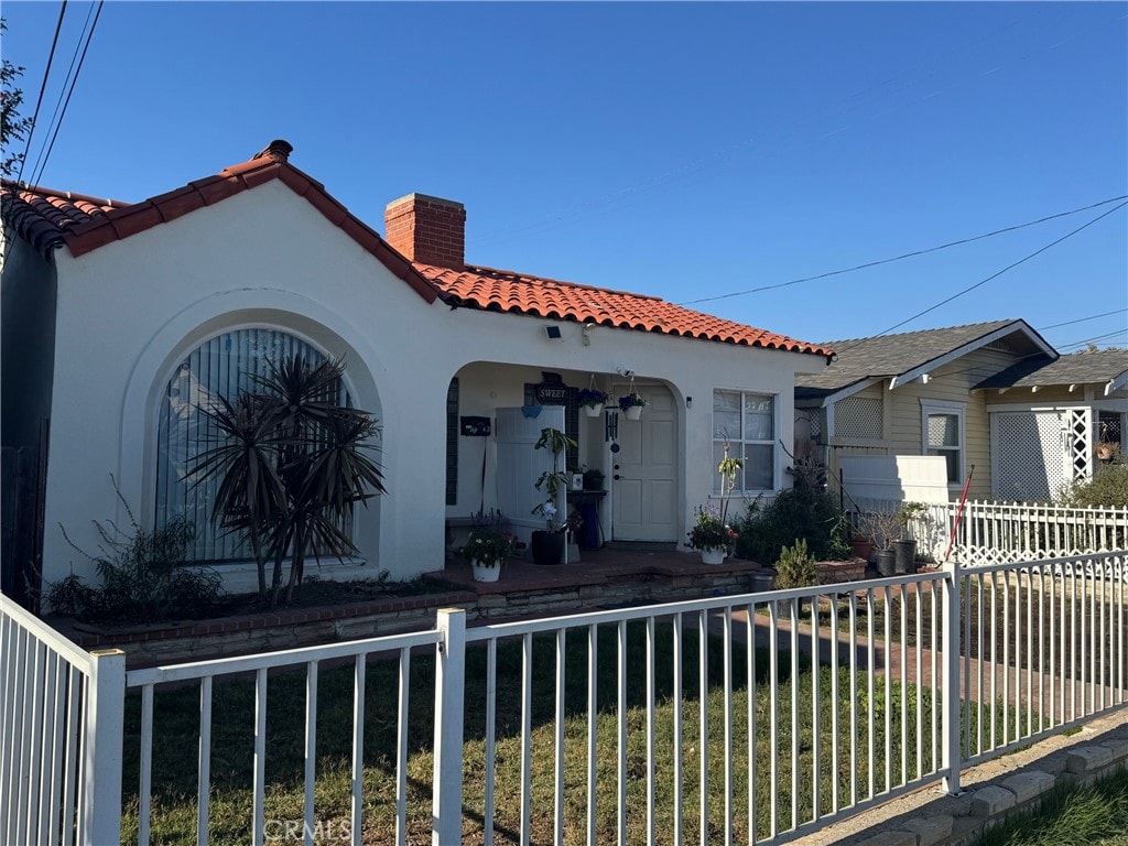 528530 W 19th St, San Pedro, CA 90731 - view of front of property with a chimney, a tiled roof, stucco siding, and a porch