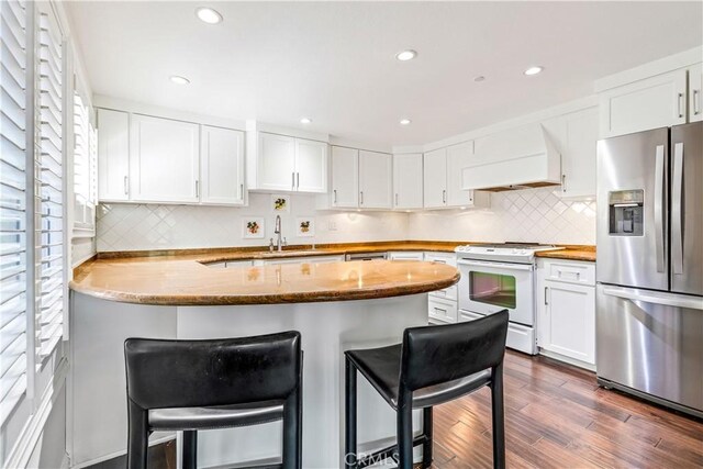 38 Canyon Island Dr Unit 38, Newport Beach, CA 92660 - kitchen featuring stainless steel refrigerator with ice dispenser, white range with electric cooktop, custom range hood, a peninsula, and dark wood finished floors