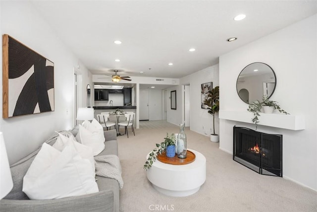 950 Cagney Ln Unit 107, Newport Beach, CA 92663 - living area with light colored carpet, recessed lighting, a ceiling fan, and a lit fireplace