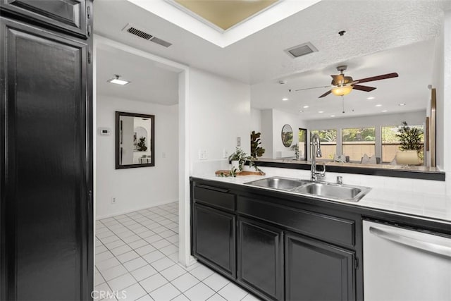 950 Cagney Ln Unit 107, Newport Beach, CA 92663 - kitchen featuring white dishwasher, ceiling fan, light tile patterned floors, dark cabinetry, and light countertops