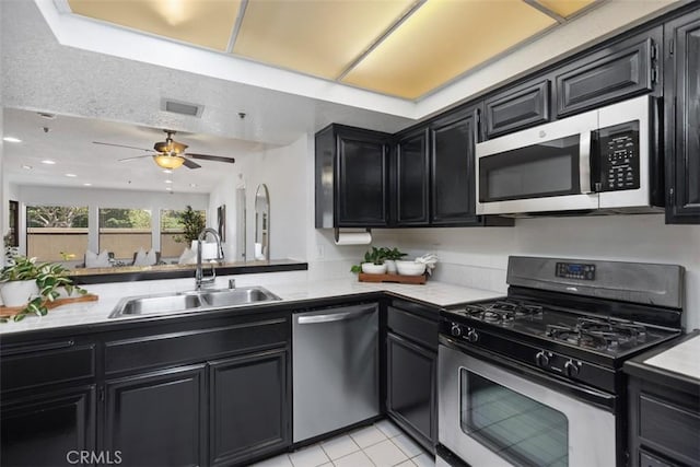 950 Cagney Ln Unit 107, Newport Beach, CA 92663 - kitchen with stainless steel appliances, dark cabinetry, light countertops, and recessed lighting