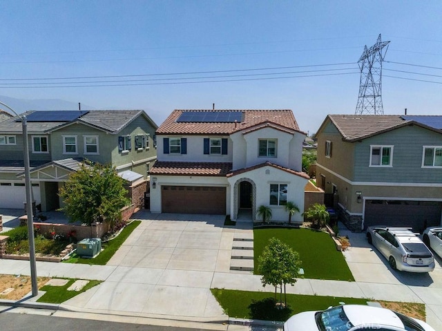 4389 Condor Ave, Fontana, CA 92336 - view of front facade with a tile roof, a garage, stucco siding, driveway, and roof mounted solar panels