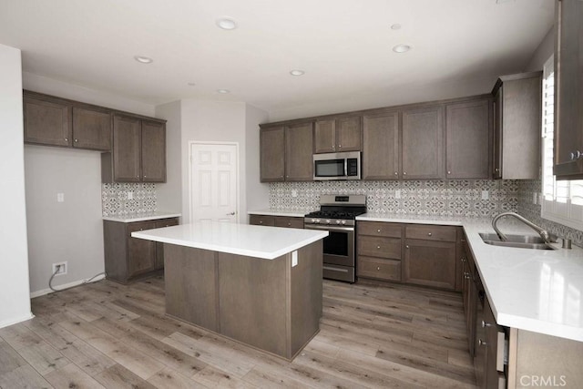 4389 Condor Ave, Fontana, CA 92336 - kitchen with appliances with stainless steel finishes, backsplash, a center island, light wood finished floors, and light countertops