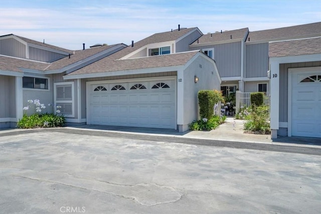 12 Sparrow Hill Ln, Laguna Hills, CA 92653 - view of front of house featuring an attached garage, roof with shingles, and driveway