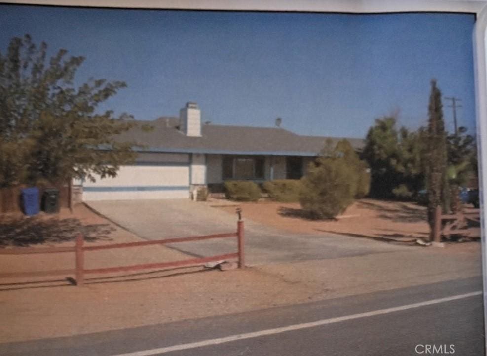 16082 Aztec Rd, Apple Valley, CA 92307 - view of front facade with driveway, an attached garage, and a chimney