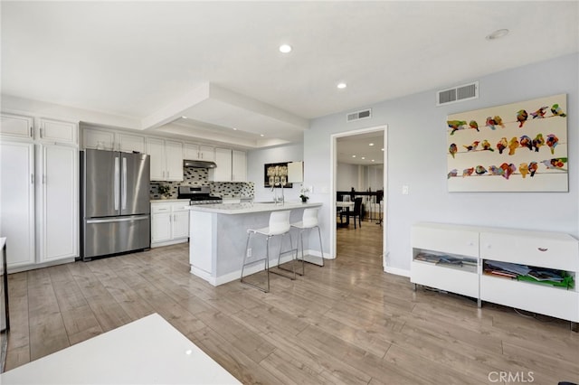 5533 Edward E Horton Ln Unit 6, Encino, CA 91316 - kitchen featuring appliances with stainless steel finishes, under cabinet range hood, a peninsula, light wood-type flooring, and decorative backsplash