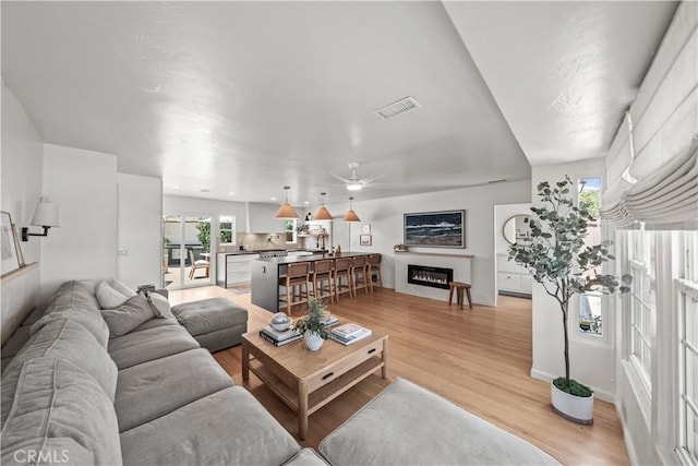 6335 Lorca Dr, San Diego, CA 92115 - living room featuring a ceiling fan, light wood-type flooring, and a glass covered fireplace