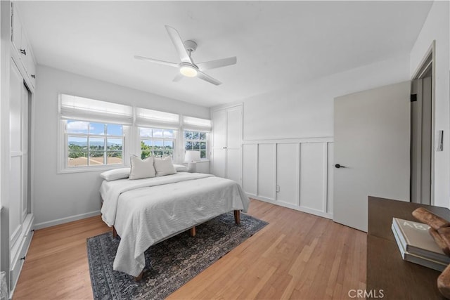 6335 Lorca Dr, San Diego, CA 92115 - bedroom with light wood-type flooring, a decorative wall, ceiling fan, and wainscoting