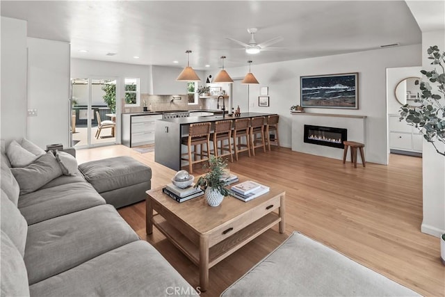 6335 Lorca Dr, San Diego, CA 92115 - living area with a ceiling fan, light wood-style floors, a glass covered fireplace, and recessed lighting