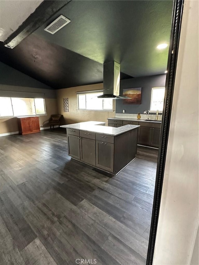 6896 Frontage Rd, Lucerne, CA 95458 - kitchen featuring island exhaust hood, vaulted ceiling, dark wood-style flooring, light countertops, and open floor plan