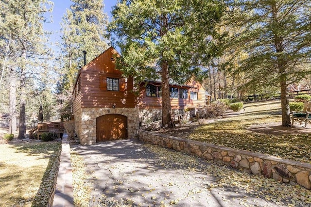39654 Flicker Rd, Fawnskin, CA 92333 - rustic home featuring stone siding, driveway, and an attached garage