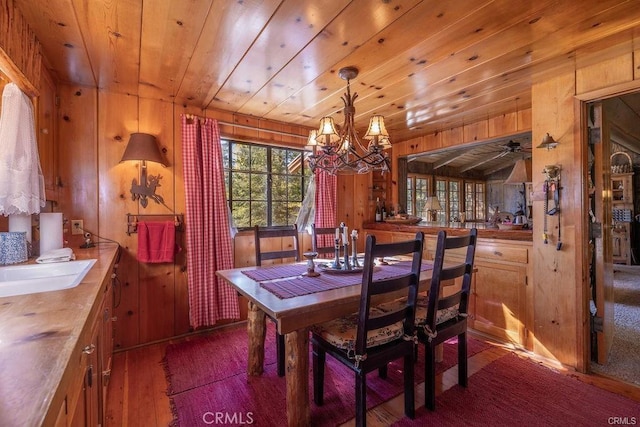 39654 Flicker Rd, Fawnskin, CA 92333 - dining area featuring dark wood finished floors, wood walls, a chandelier, and wooden ceiling
