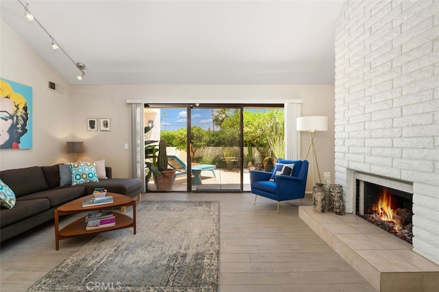 72760 Sage Ct, Palm Desert, CA 92260 - living area featuring wood finished floors, rail lighting, a brick fireplace, and lofted ceiling
