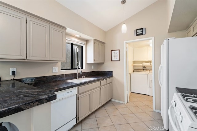 72760 Sage Ct, Palm Desert, CA 92260 - kitchen with white appliances, independent washer and dryer, vaulted ceiling, dark countertops, and decorative light fixtures