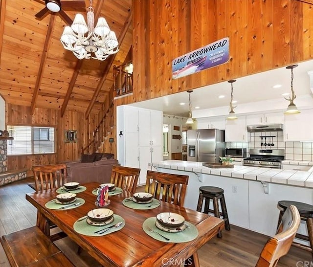 1126 Aleutian Dr, Lake Arrowhead, CA 92352 - dining space with wood walls, wood finished floors, stairway, a chandelier, and high vaulted ceiling
