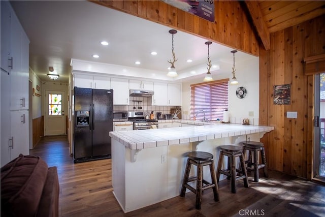 1126 Aleutian Dr, Lake Arrowhead, CA 92352 - kitchen featuring stainless steel appliances, under cabinet range hood, a peninsula, tile counters, and dark wood-style flooring