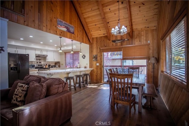 1126 Aleutian Dr, Lake Arrowhead, CA 92352 - dining space featuring wooden walls, dark wood-style flooring, a chandelier, a wood ceiling with exposed beams, and high vaulted ceiling