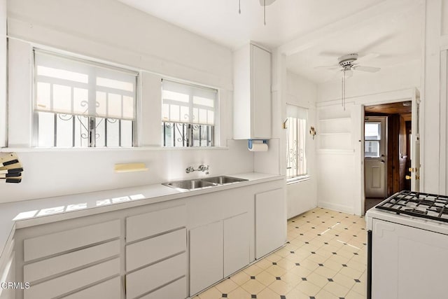 2710 W Shorb St, Alhambra, CA 91803 - kitchen with white stove, ceiling fan, white cabinets, light countertops, and light flooring
