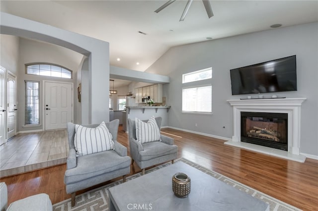 2925 E El Paso Ave, Fresno, CA 93720 - living room with wood finished floors, lofted ceiling, a glass covered fireplace, arched walkways, and ceiling fan