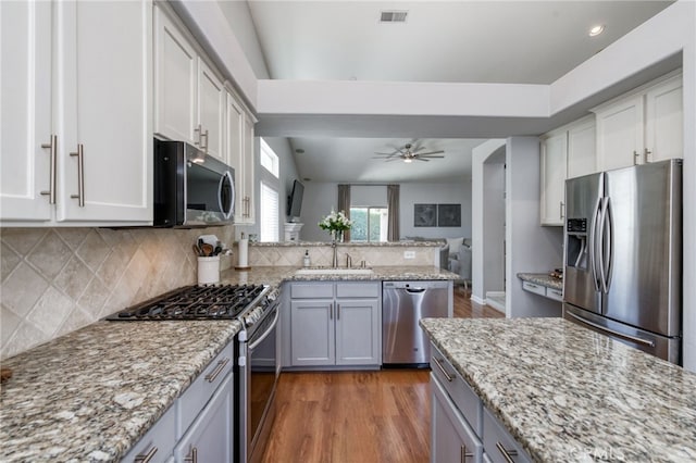 2925 E El Paso Ave, Fresno, CA 93720 - kitchen featuring stainless steel appliances, tasteful backsplash, light wood-style flooring, ceiling fan, and a peninsula
