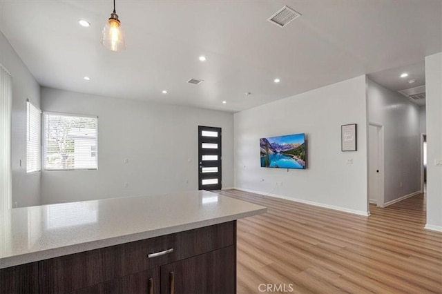 7820 Fulton Ave, North Hollywood, CA 91605 - kitchen featuring open floor plan, light wood-style floors, recessed lighting, dark brown cabinets, and hanging light fixtures